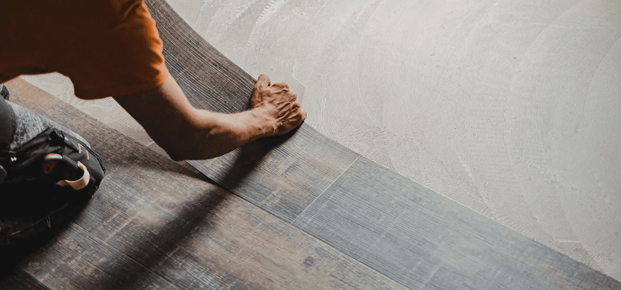 Hands placing vinyl floor tiles