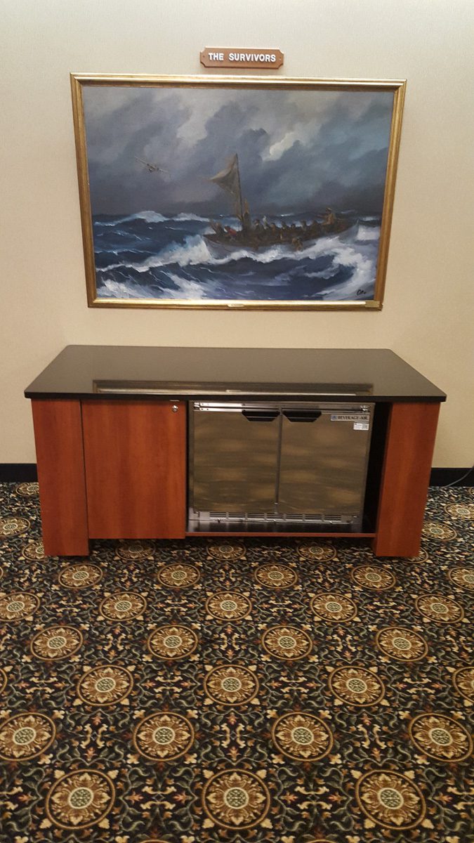 Painting above wooden cabinet with patterned carpet.