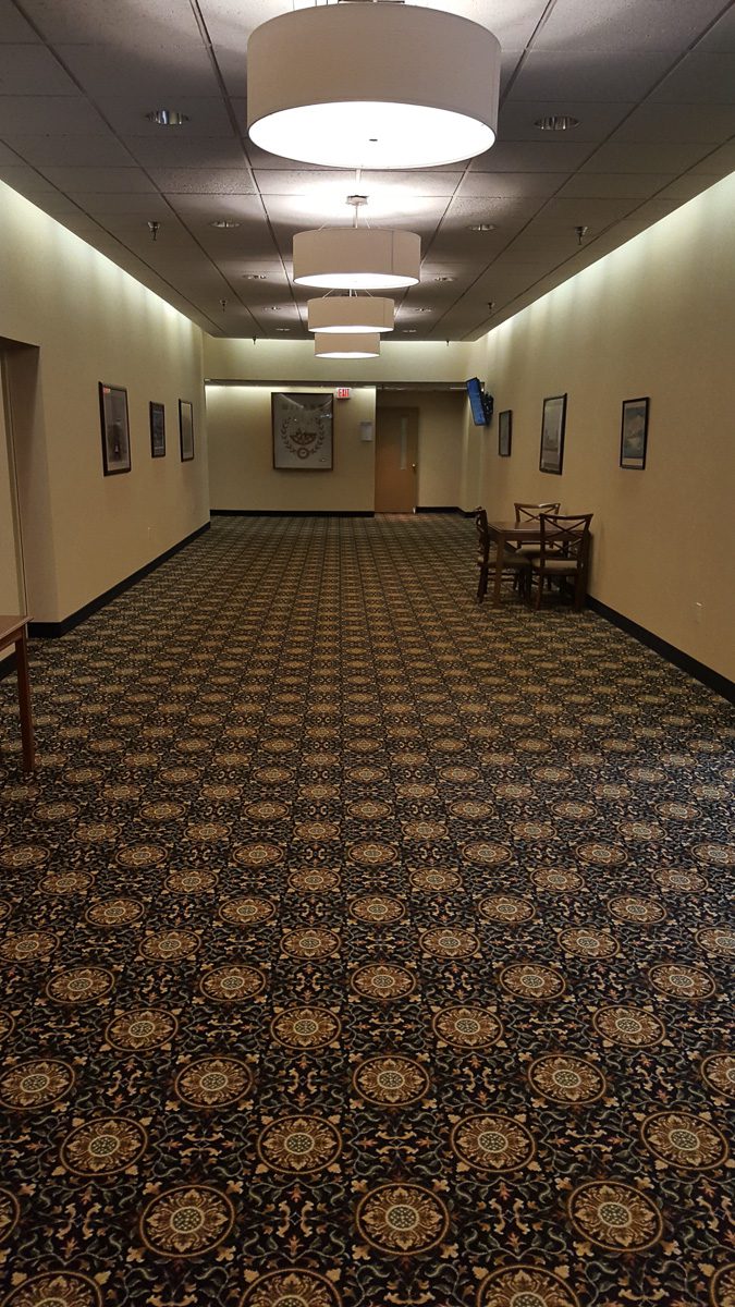 Carpeted hallway with framed pictures