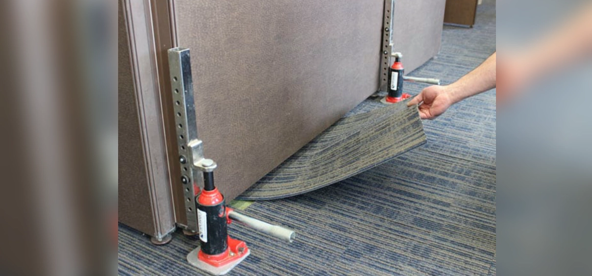 Lifting carpet with hydraulic jacks and hand.