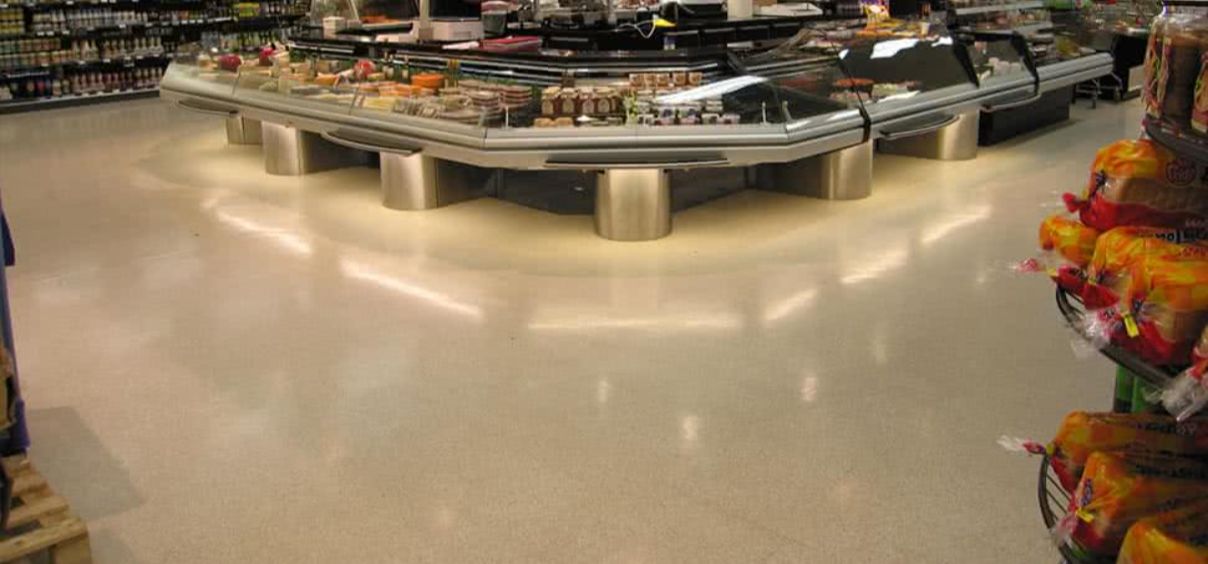 Supermarket deli counter with various food items.