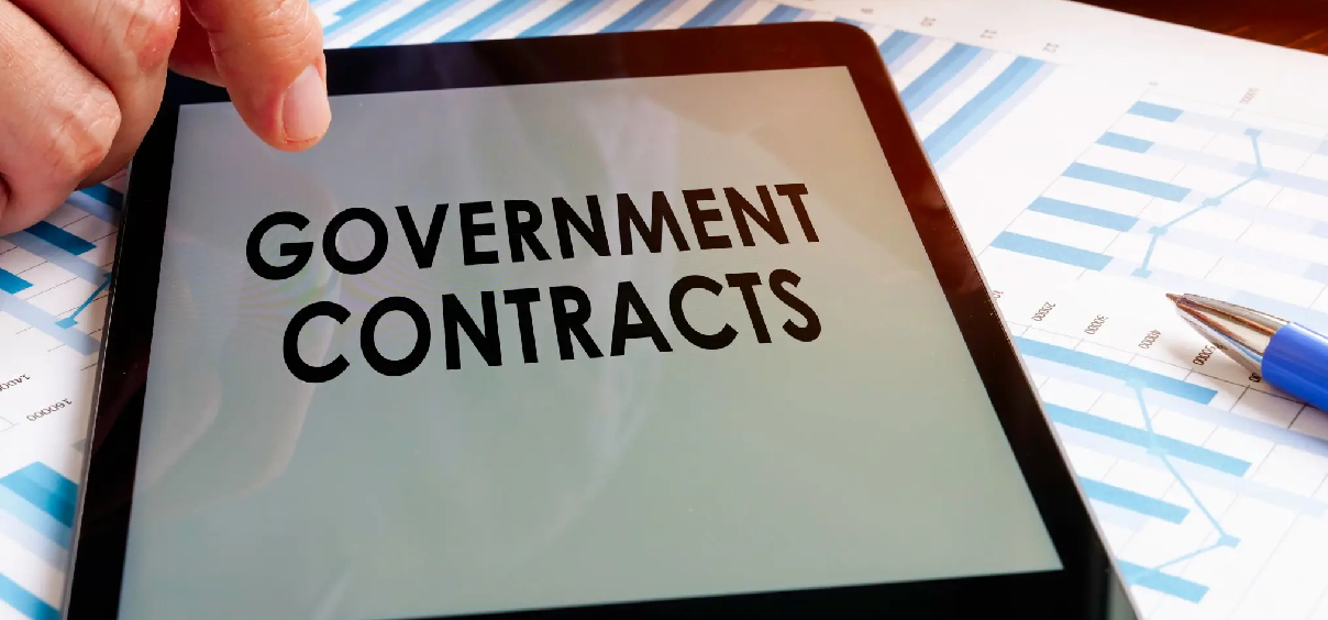 Tablet displaying "Government Contracts" on screen.
