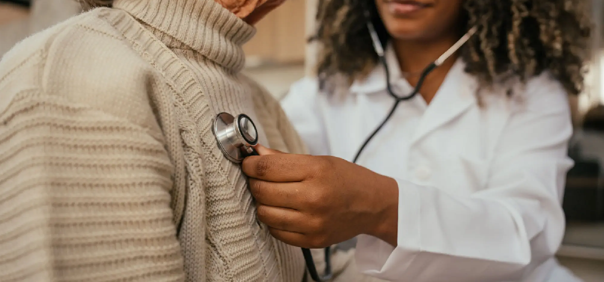 Doctor using stethoscope on patient.