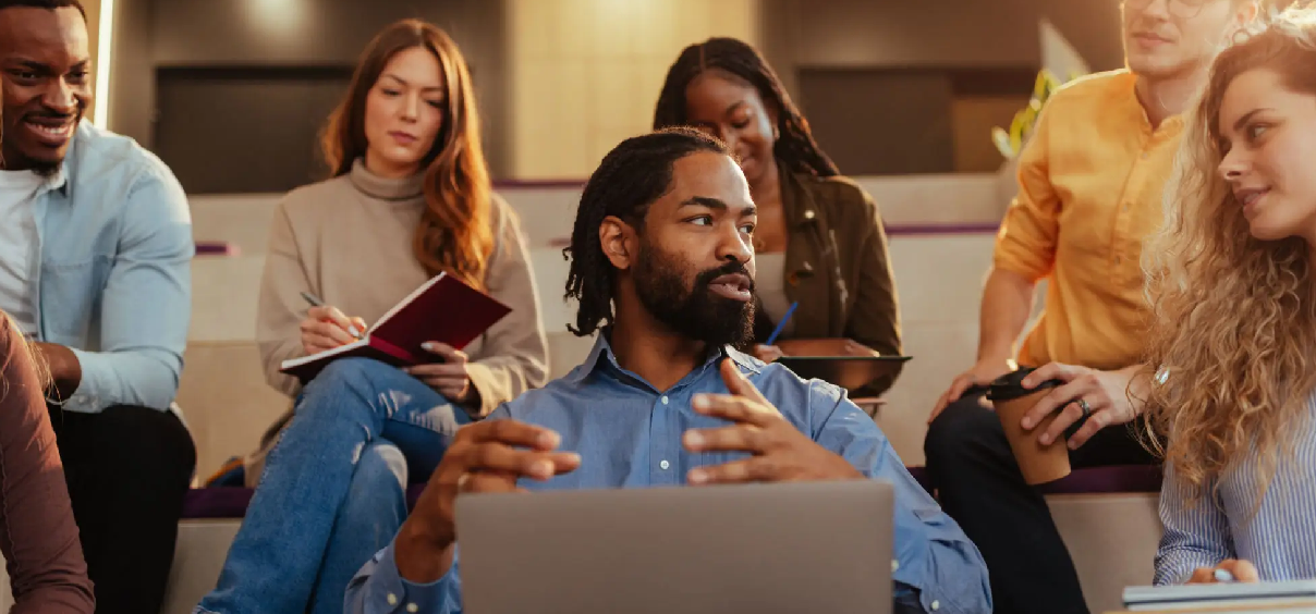 Group discussion with diverse people and laptops.