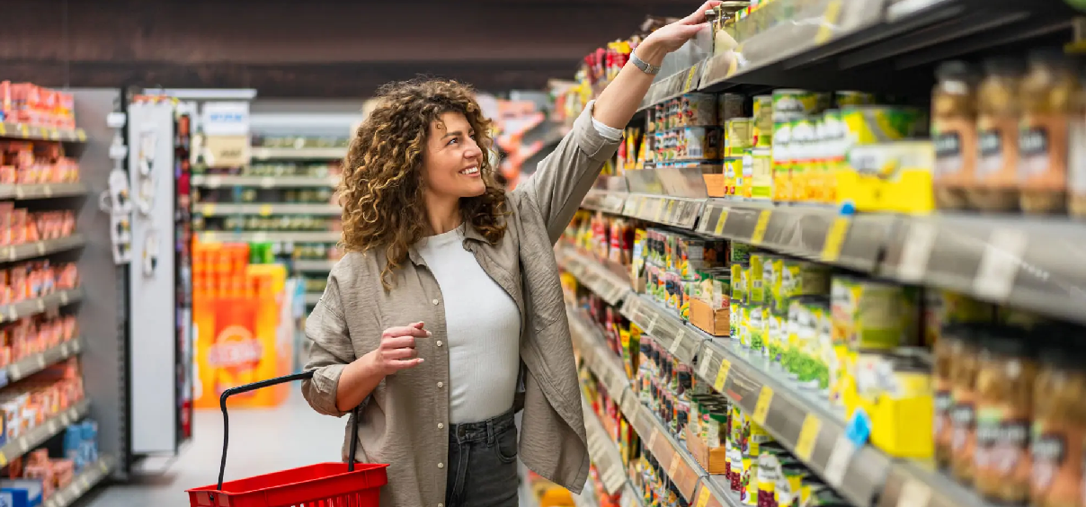 Woman shopping in a grocery store aisle.