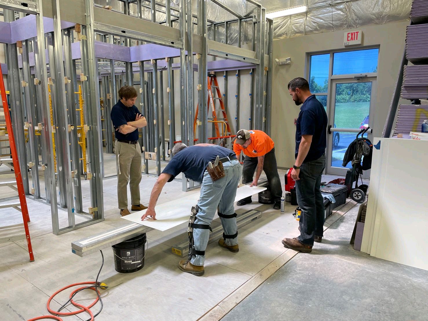 Construction workers measuring materials at building site.