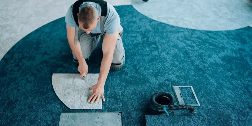 Man installing carpet on the floor.