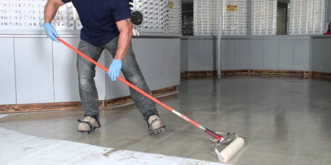 Applying epoxy coating to a concrete floor.