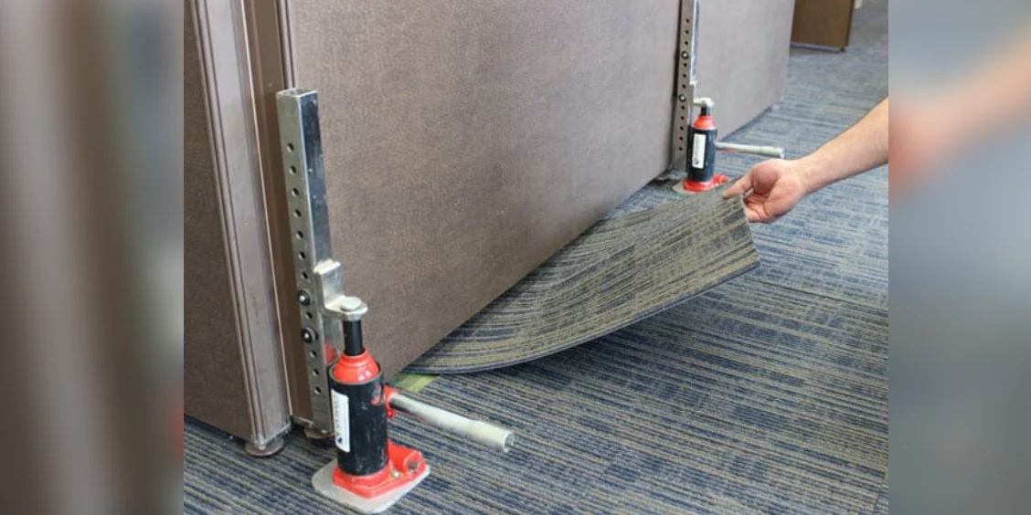 Lifting carpet with hydraulic jacks and hand.